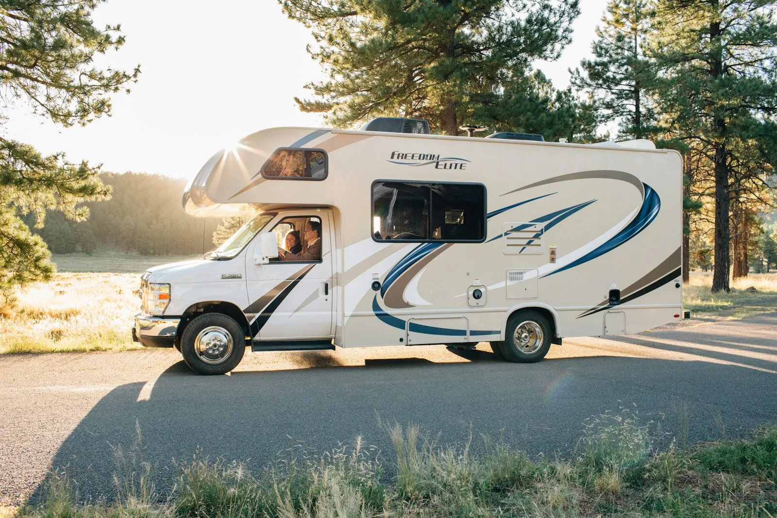 Modern motorhome driving on a road through a forest